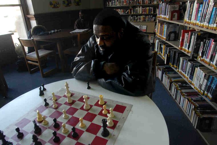 Prentiss Truluck studies a move. "It's just sad that the library has to be one of the casualties of politics," a security guard said.