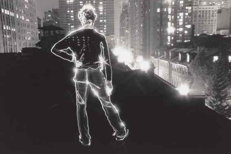 "Angelo on the Roof" by David Lebe, a 1979 gelatin silver print, in "Common Ground." It's one of Lebe's time-exposure "light-drawings," figures in dark settings outlined with a moving penlight.
