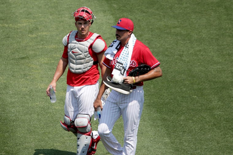 Phillies pitcher Zach Eflin, right, talks things over with catcher J.T. Realmuto after a bullpen session last week.