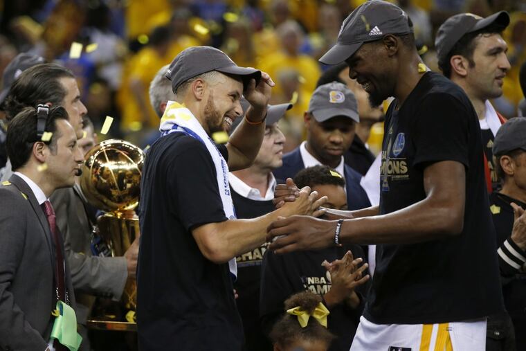 The Golden State Warriors' Stephen Curry and Kevin Durant, right, celebrate after defeating the Cleveland Cavaliers, 129-120, in Game 5 of the NBA Finals at Oracle Arena in Oakland, Calif., on Monday, June 12, 2017.