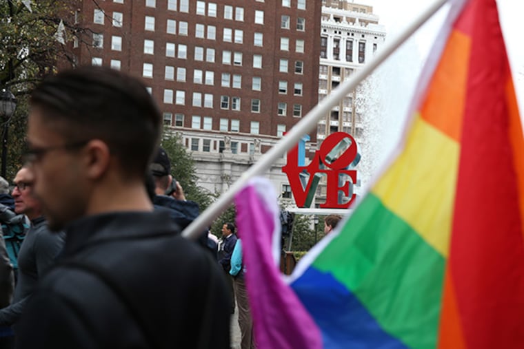 Tom Hall holds a rainbow flag during a rally to support hate crime legislation at Love Park on September 25, 2014 in Philadelphia. Reported hate crimes have risen in recent years, the majority of them motivated by racism.