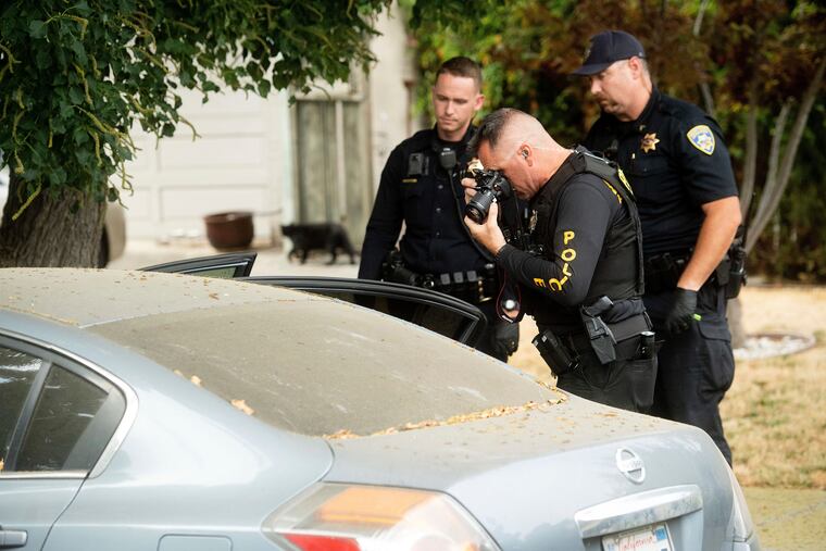 A police officer photographs a car outside the family home of Gilroy Garlic Festival gunman Santino William Legan on Monday, July, 29, 2019, in Gilroy, Calif.
