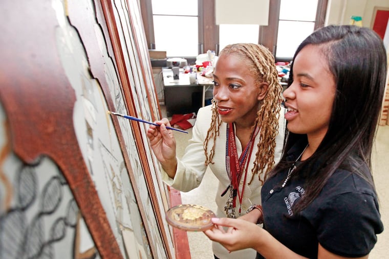 Karren Dunkley (left), principal of Parkway Center City High, paints with student Aighnyey Cleveland, 17. Dunkley is in her second year at the school and is one of seven winners. MICHAEL BRYANT / Staff Photographer