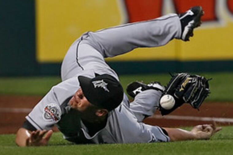Marlins leftfielder Todd Linden goes tumbling in an attempt to field a foul ball hit by the Phillies' Abraham Nuñez.