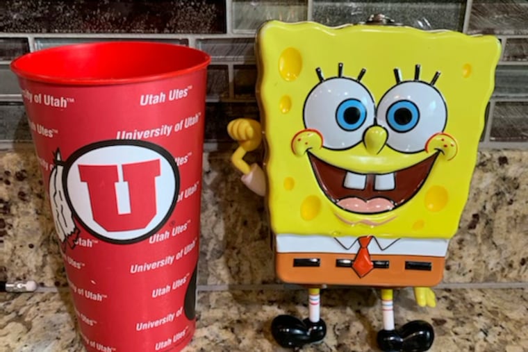 In this photo provided by Utah sports writer Andy Larsen are a childhood piggybank, right, and a plastic cup on Tuesday, Nov. 24, 2020, in Salt Lake City. Larsen's spontaneous tweet looking for someone in need to whom he could give the $165 he had in the two items quickly snowballed into tens of thousands of dollars in donations from strangers, as well as messages from people who could use the help. (Andy Larsen via AP)