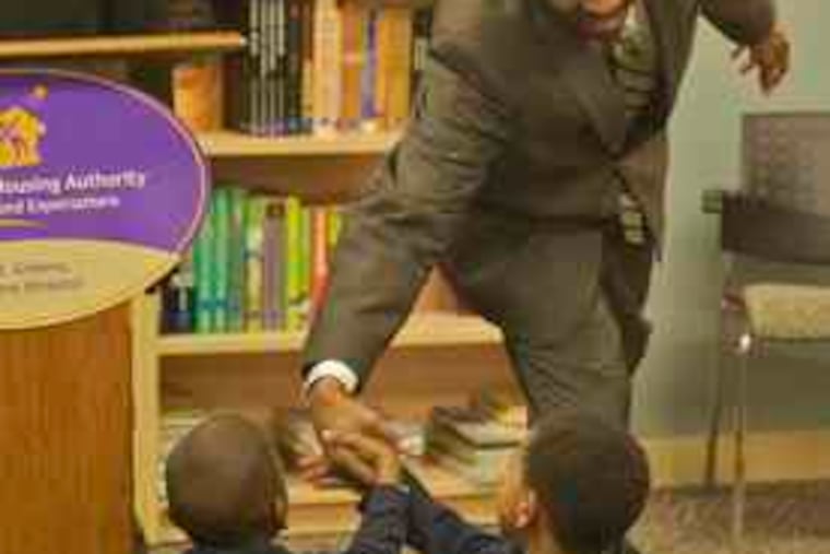 City Councilman Darrell Clarke greets youngsters , above, at the Housing Authority's new library inside the John F. Street Community Center at 11th and Poplar Streets. It will serve the families living in North Philadelphia's Richard Allen and Cambridge housing developments. Above left, Kyarea Smith (left), 12, and Nasihah White, 11, at the ribbon-cutting.