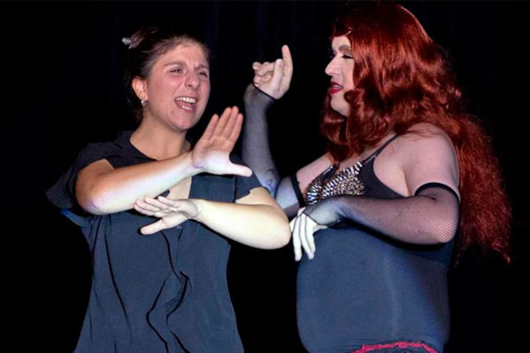 Holly Maniatty, left, signs during a performance by a contestant in the Royal Majesty Drag Show and Competition in Portland, Maine, last week. (Robert F. Bukaty/Associated Press)
