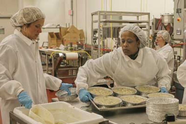 Kathy Herring (left), co-owner of The Twin Hens, and production assistant Melvonne Payne producing chicken potpies at the Rutgers Food Innovation Center in Bridgeton, N.J. (Akira Suwa / Staff Photographer )