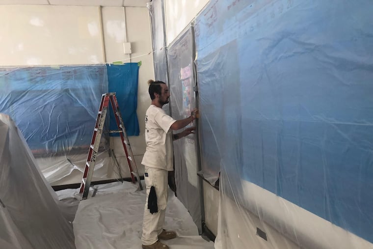 A worker performs lead paint and plaster stabilization at Clara Barton Elementary School.