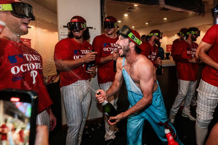 Phillies catcher Garrett Stubbs sprays champagne on teammates after the Phillies clinched a postseason berth for the second time in as many seasons.