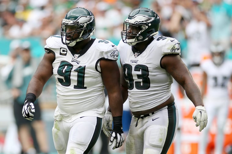 Defensive tackle Tim Jernigan (93), who was twice called for roughing the passer in Sunday's loss to the Dolphins, talks with Fletcher Cox (91) during the game.