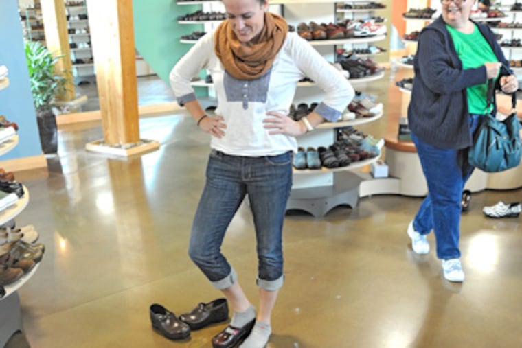 To find the right fit, Sarah Horstmann, a nurse from Washington, eyes an array of clogs at the Dansko outlet store. (Clem Murray / Staff Photographer)