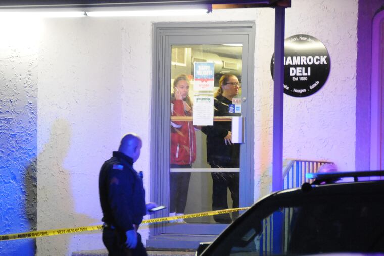 The rear entrance to Shamrock Delicatessen in Audubon is blocked off by crime-scene tape early Friday evening as employees stand inside following the fatal stabbing of owner Jerome Pastore.