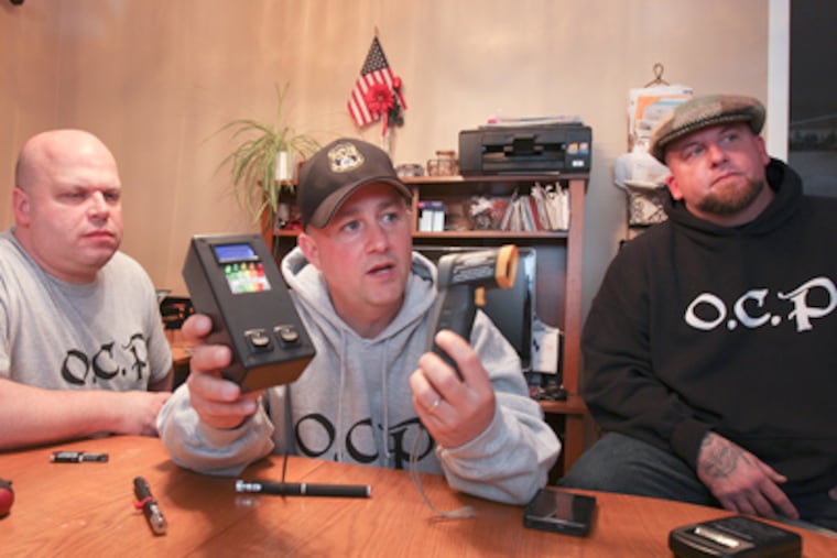John Levy holds an electromagnetic field gauge that is said to sense when spirits are around. Levy, George Feinstein (left) and Steve Rotondi investigate spooks for the group Olde City Paranormal. (Steven M. Falk / Staff Photographer)
