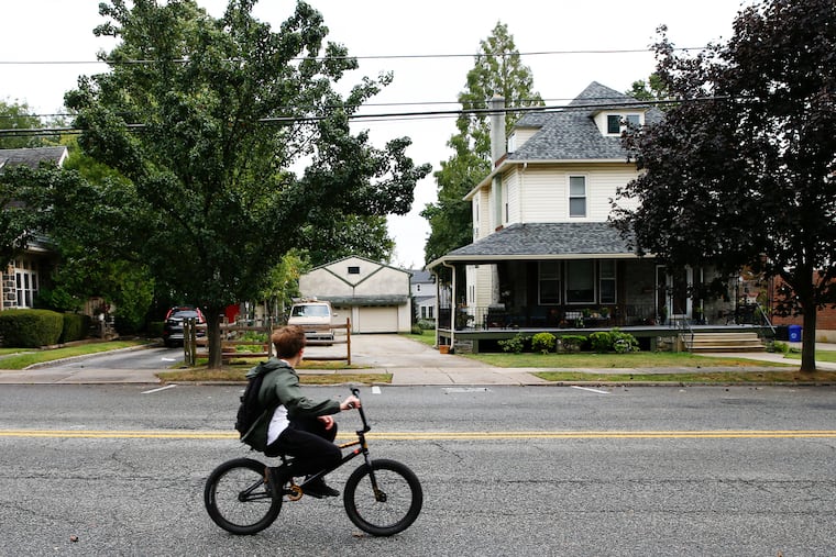 A cyclist rides past by homes along Brookline Blvd in Havertown.