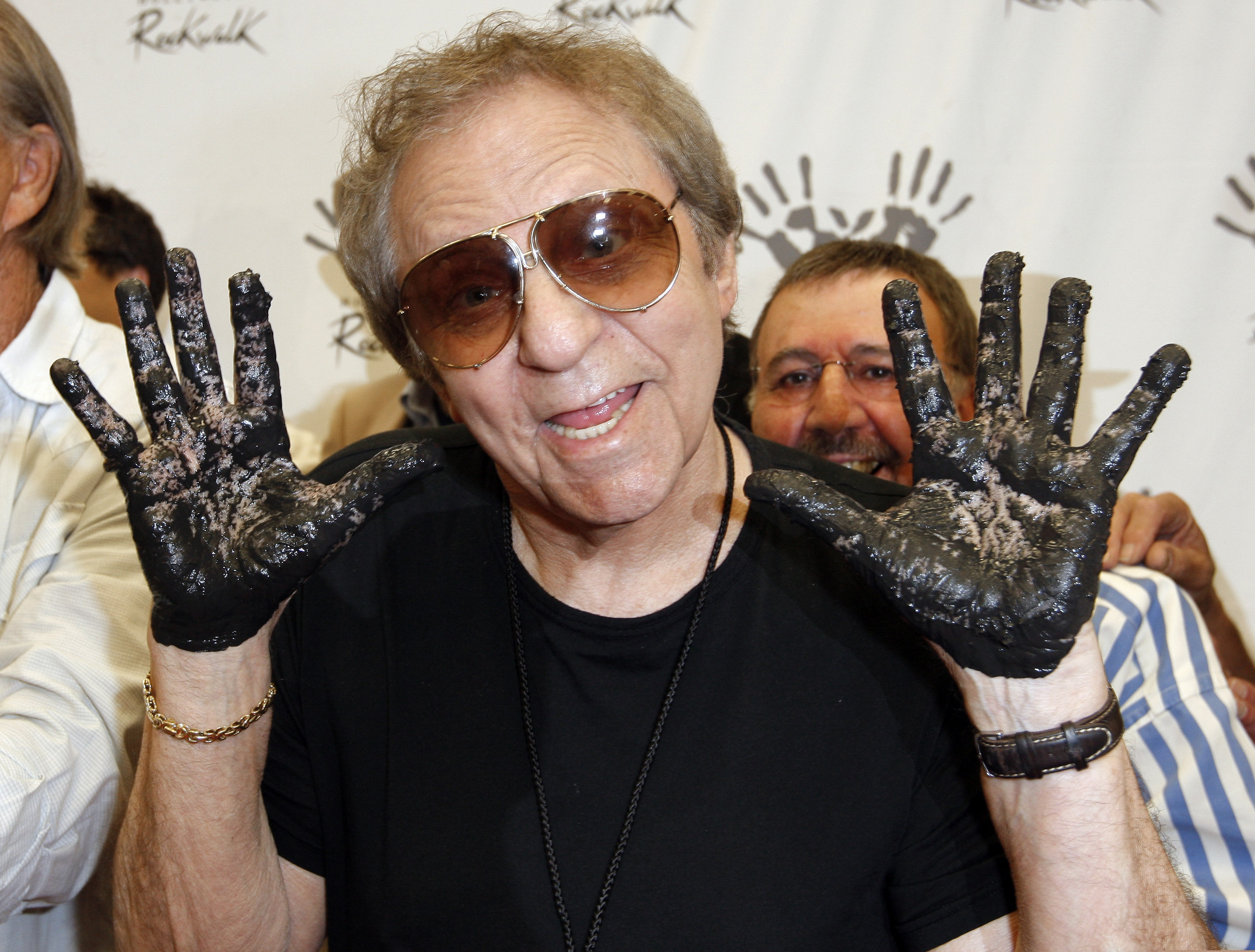 FILE - In this June 25, 2008, file photo, Hal Blaine holds up his hands covered in cement after placing them in wet cement with Don Randi and Glen Campbell, representing the Wrecking Crew following an induction ceremony for Hollywood's RockWalk in Los Angeles. Drummer Blaine, who played on many of the biggest hits in music history, has died. Blaine's son-in-law Andy Johnson tells the Associated Press that Blaine died of natural causes Monday, March 11, 2019, at his home in Palm Desert, Calif. He was 90.