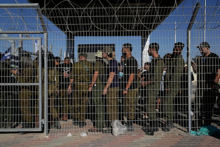 Israeli soldiers gather at the gate to the Sde Teiman military base, as people protest in support of soldiers being questioned for detainee abuse, July 29, 2024. On Thursday the military dropped the charges against five soldiers.