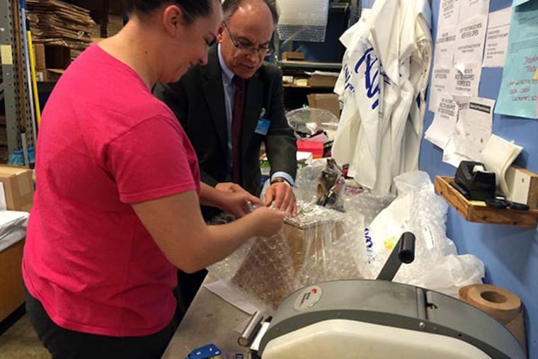 Boscov’s vice chairman Jim Boscov helps Danielle Hulings of Bristol wrestle bubble wrap onto an online order Monday, Dec. 16, 2013, at the Neshaminy Mall store. (Maria Panaritis/Staff)