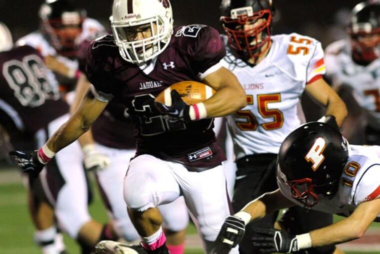 Garnet Valley running back Jake Irving out runs Penncrest defenders Bobby McCAfferty, right and Clay Anderson, center, on his way to a touchdown in the first quarte of play Friday, Oct. 4, 2013 in Glen Mills, Pa. (Bradley C Bower/Staff Photographer))