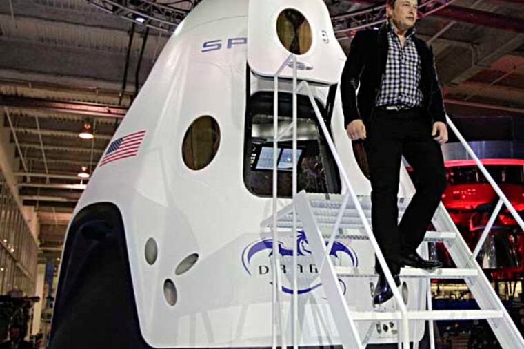 Elon Musk, of SpaceX, walks down the steps while introducing the SpaceX Dragon V2 spacecraft Thursday, May 29, 2014, in Hawthorne, Calif. SpaceX, which has flown unmanned cargo capsules to the International Space Station, unveiled the spacecraft, which is designed to ferry up to seven astronauts to the International Space Staion. (AP Photo/Jae C. Hong)