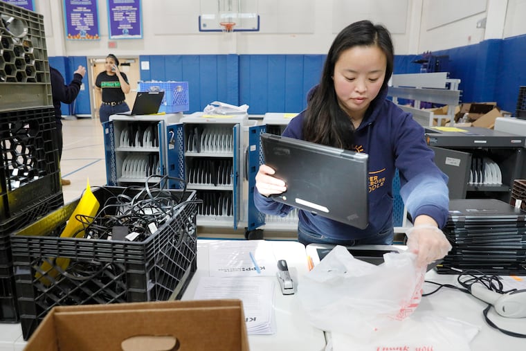 KIPP Cooper Norcross Academy’s managing director of school operations Amanda Poole gets laptops ready for the volunteers that will take them to the students that were not able to pick them up on March 27, 2020. Because of coronavirus schools need to readjust their teaching methods while students are staying safe at home. The KIPP Cooper Norcross Academy in Camden is supplying its K-8th grade students with laptops so students will still be able to learn remotely.