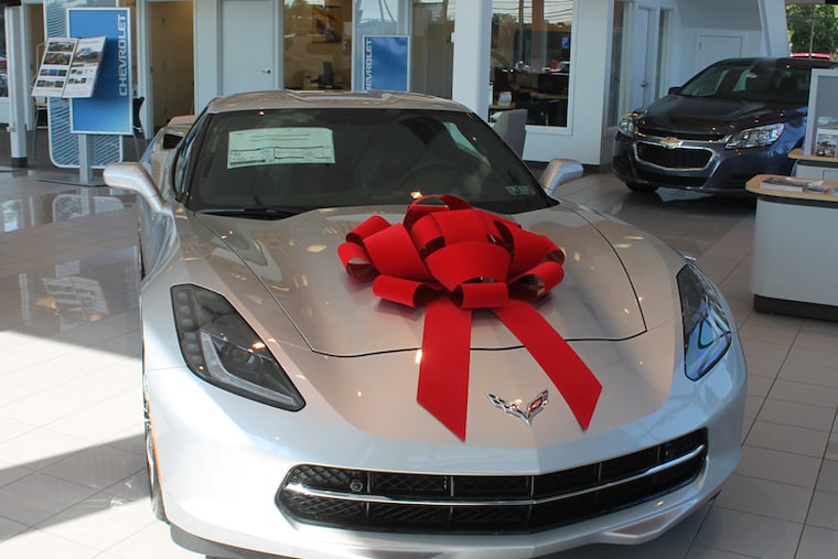 A 30-inch velvet car bow atop a Chevrolet Stingray at a car dealership.