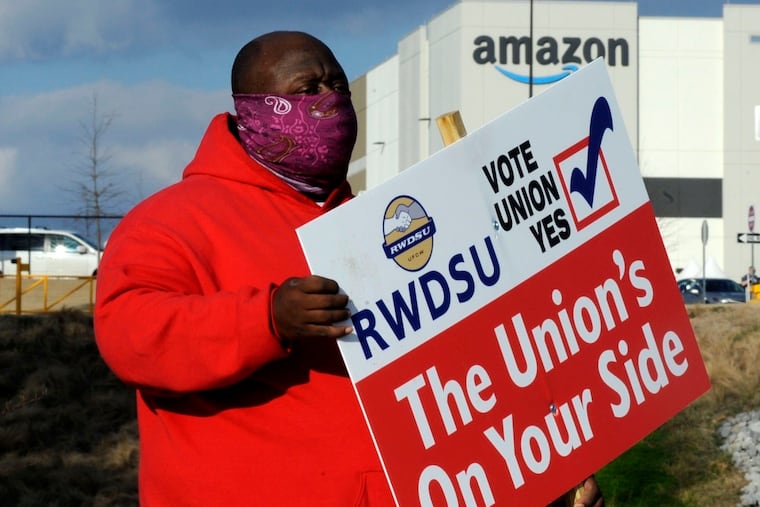 Michael Foster of the Retail, Wholesale and Department Store Union holds a sign outside an Amazon facility where labor is trying to organize workers. President Joe Biden said workers in Alabama and across the country have the right to join a union without intimidation from their companies. His comments come as Amazon workers in the state are voting on whether they should unionize.