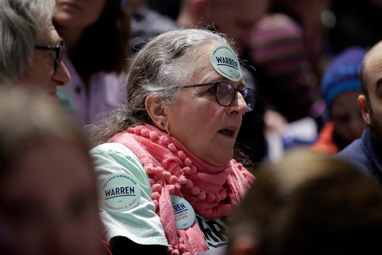 A woman caucusing for Democratic presidential candidate Sen. Elizabeth Warren, D-Mass., sits in the Warren section at the Precinct 68 caucus at the Knapp Center on the Drake University campus as the night of caucusing gets underway in Des Moines, Iowa. After female candidates helped power the Democratic party to retake the House in 2018 the party's women seem only moderately enthusiastic about voting for a woman for president.