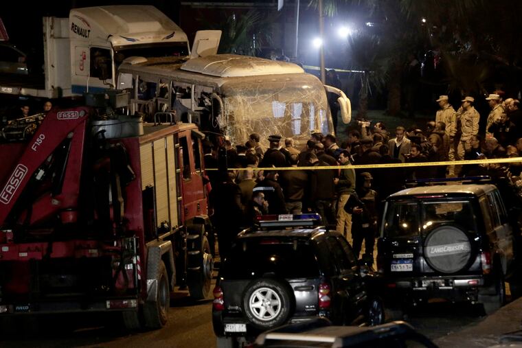 Security forces stand near a tourist bus after a roadside bomb in an area near the Giza Pyramids in Cairo, Egypt. Egypt's Interior Ministry said in a statement that two Vietnamese tourists were killed and others wounded, in the incident.