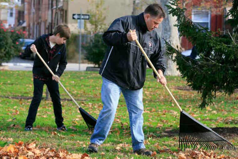 The "Fall for Your Park" project brought volunteers to city streets and parks, including Port Richmond's Campbell Square. Above, Andy McLaughlin and son Joe rake. At top right, Christine Long uses a grabber to collect trash. She no longer lives in the area but came yesterday with her husband, Bill. And at right, Lisa O'Malley, who was raking, takes a break with son Danny Dabrowski.