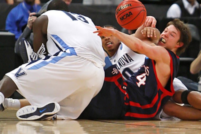 'Nova's Mouphtaou Yaru, left, and Corey Fisher battle Saint Mary's Matthew Dellavedova for a loose ball. (Ron Cortes / Staff Photographer)