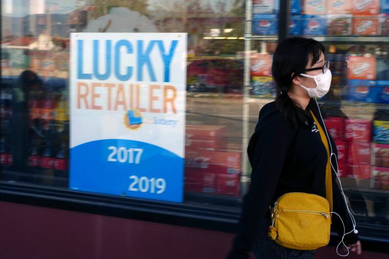A pedestrian wears a protective mask in Alhambra, Calif., Friday, Jan. 31, 2020. As China grapples with the growing coronavirus outbreak, Chinese people in the Los Angeles area, home to the third-largest Chinese immigrant population in the United States, are encountering a cultural disconnect as they brace for a possible spread of the virus in their adopted homeland.