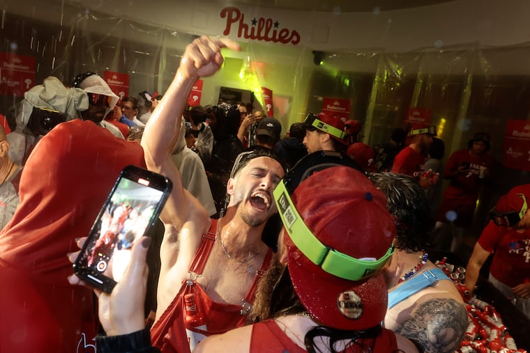 Catcher Garrett Stubbs celebrates with his Phillies teammates in the locker room after the wild-card sweep of the Miami Marlins was complete.
