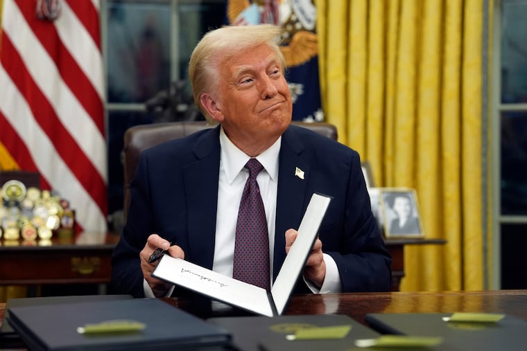 President Donald Trump signs executive orders in the Oval Office of the White House on Monday.