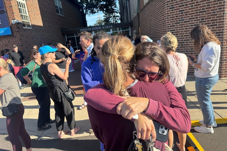 Parents wait outside of Annunciation Catholic School in Minneapolis after a shooting on Wednesday morning.