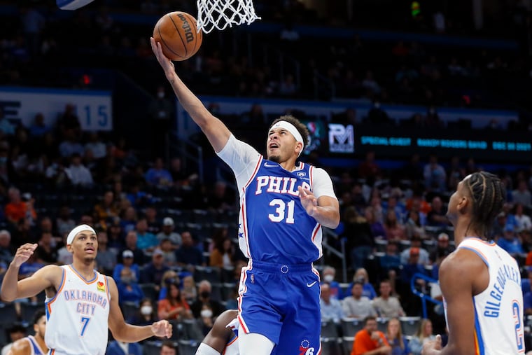 Philadelphia 76ers guard Seth Curry (31) shoots between Oklahoma City Thunder guards Darius Bazley (7) and Shai Gilgeous-Alexander (2) in the first half of an NBA basketball game Sunday, Oct. 24, 2021, in Oklahoma City. (AP Photo/Nate Billings)