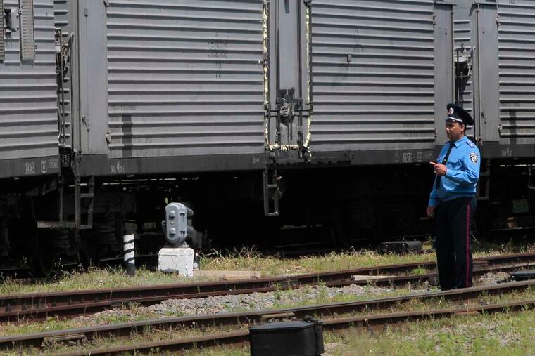 A police officer stands near a refrigerated train loaded with bodies of the passengers of Malaysian Airlines Flight 17 at the railway station in Kharkiv, which is controlled by Ukrainian forces.
