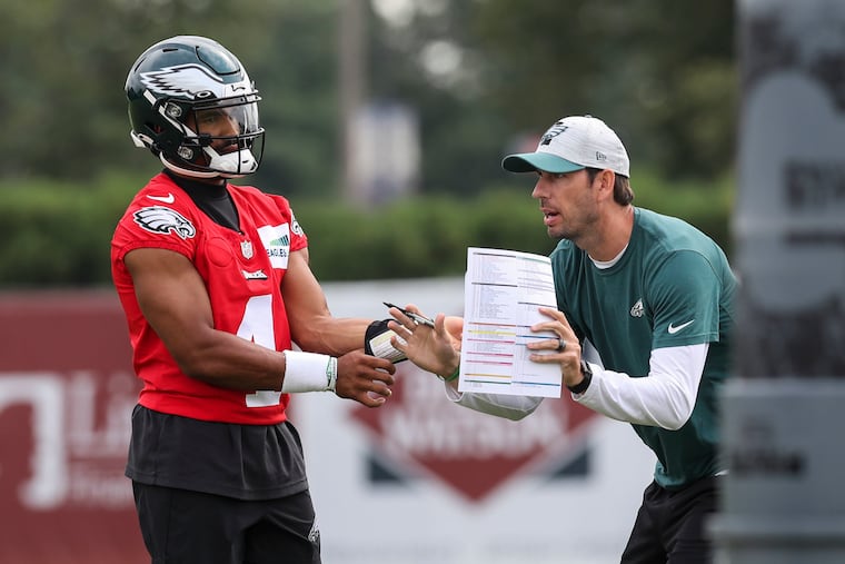 Eagles quarterback Jalen Hurts talks with offensive coordinator Shane Steichen during practice Tuesday at the NovaCare Complex.