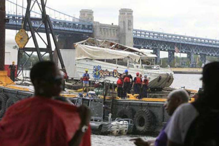 People watch Friday's salvage operation of the Ride the Ducks boat in the river off Penn's Landing. A craft will be taken out on the Delaware River today to conduct tests. (Akira Suwa / Staff Photographer)