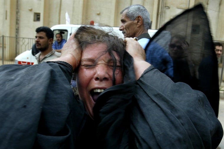 An Iraqi woman screams upon arriving with her wounded husband and son at al-Kindi hospital in 2003 in Baghdad.