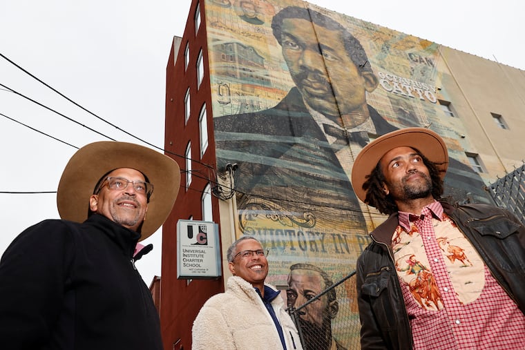 From left, brothers Ken, Haile, and Keir Johnston near the Octavius V. Catto mural that Keir Johnston and his team painted at the Universal Institute Charter School, on Monday, April 6, 2025.