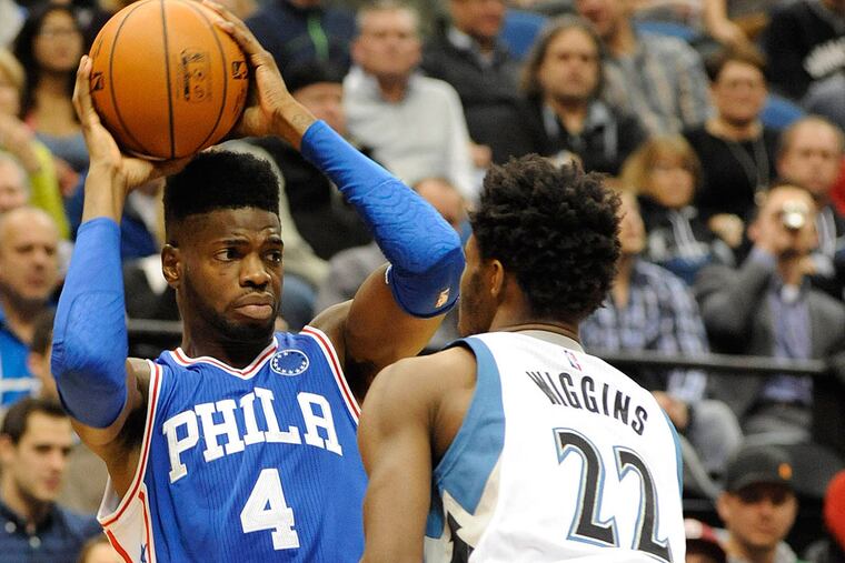 Philadelphia 76ers forward Nerlens Noel (4) looks to pass over Minnesota Timberwolves guard Andrew Wiggins (22) in the second quarter at Target Center.