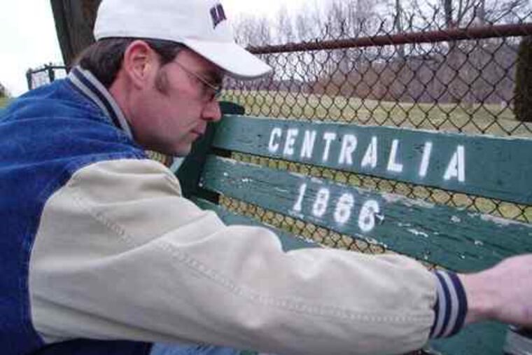 John Lokitis, one of the last residents of fire-ruined Centralia, Pa., paints a bench. He is featured in Georgie Roland's "The Town That Was."