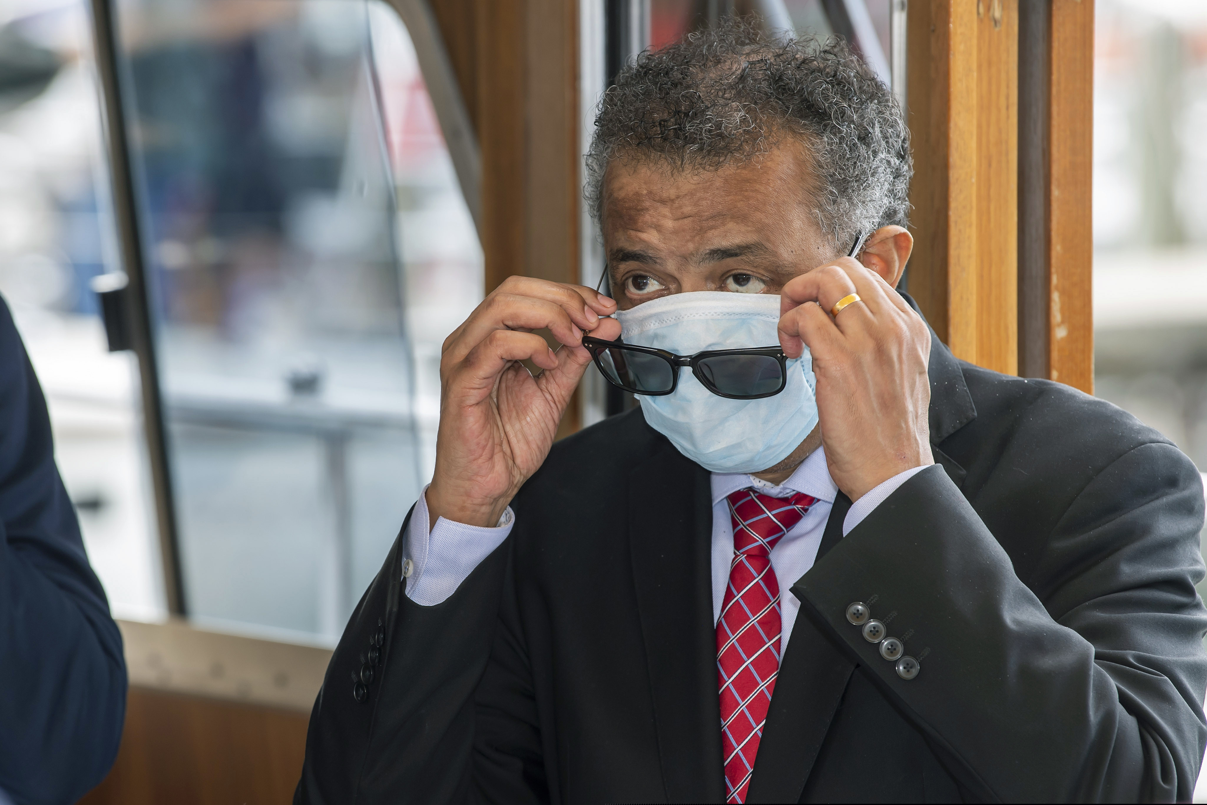 World Health Organization Director-General Tedros Adhanom Ghebreyesus puts on a face mask.