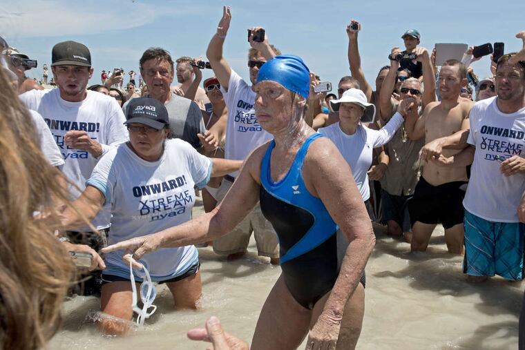 Diana Nyad, 64, emerges from the Atlantic after becoming the first person to make a Cuba-to-Florida swim without a shark cage. "You're never too old to chase your dream," she said.