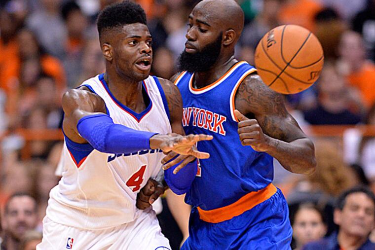 76ers forward Nerlens Noel passes the ball with Knicks forward Quincy Acy. (Mark Konezny/USA Today Sports)