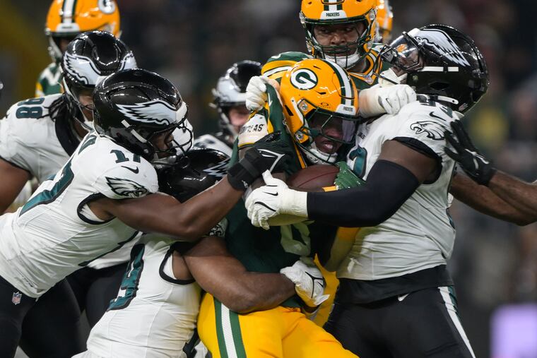 Green Bay Packers running back Josh Jacobs is tackled by Eagles linebacker Nakobe Dean (left) and defensive tackle Milton Williams (right) during the season opener at Corinthians Arena in São Paulo, Brazil.