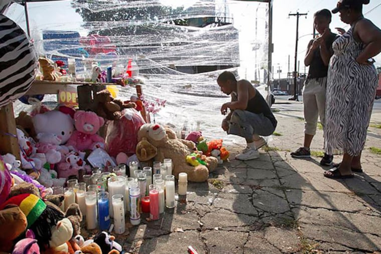 Mourners visit the shrine at Allegheny and Germantown Avenues where three young children were killed.