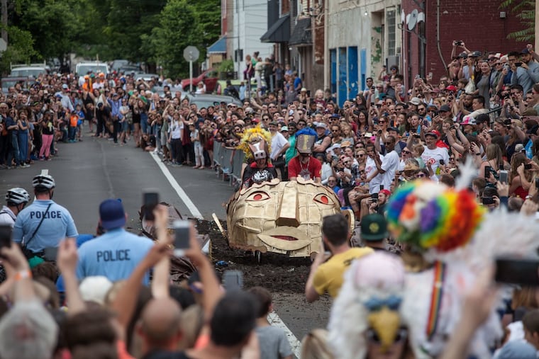A group riding a bike that's been decorated as a gold head takes part in the Kensington Derby & Arts Festival, returning to the neighborhood May 13.