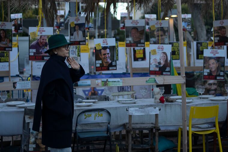 A woman looks at a display of empty chairs Friday in Tel Aviv, Israel, representing hostages held by Hamas in the Gaza Strip.